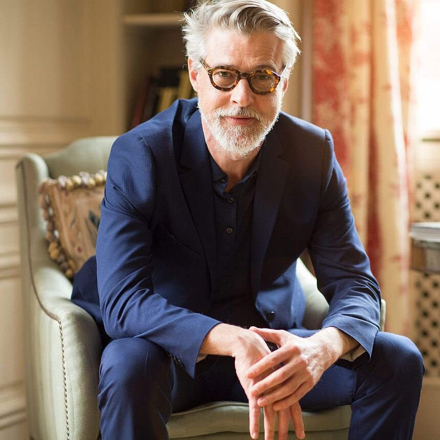 Smart investments in the future of the hotel industry Experienced businessman in a stylish suit sits relaxed in an elegant hotel lounge and looks confidently