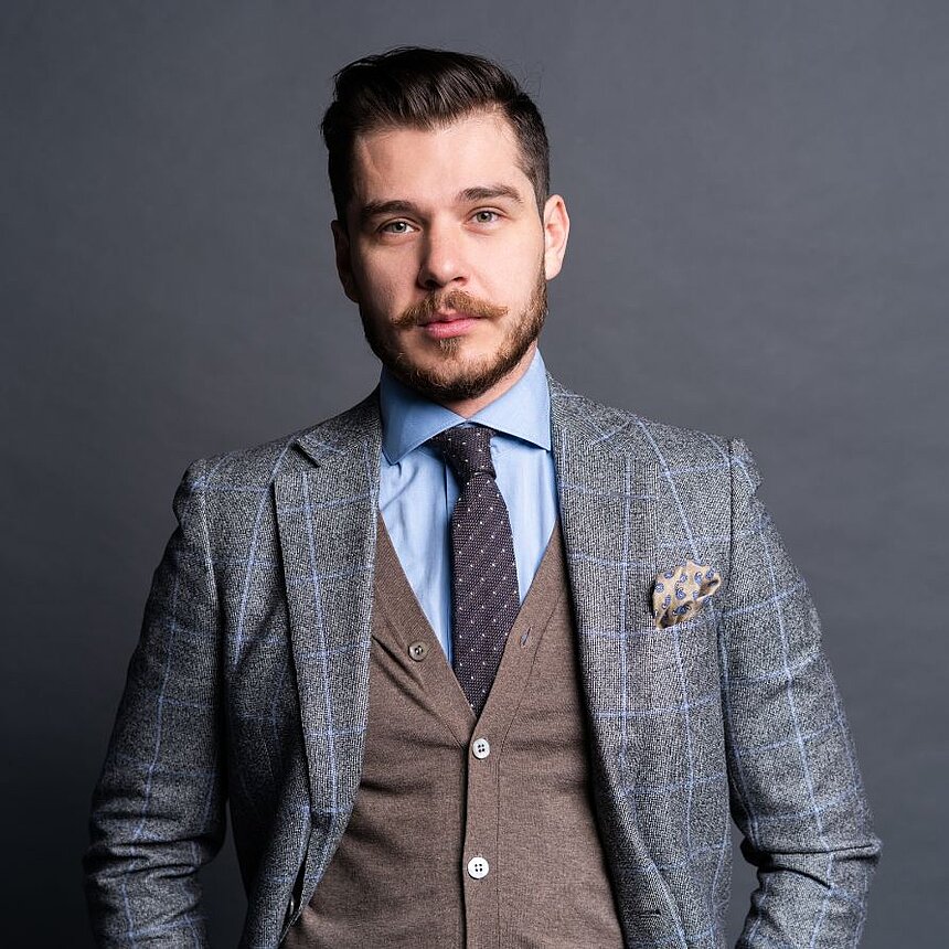 Hosts with passion - your success in the hotel industry Stylishly dressed hotelier with a modern suit and a confident look - competence and elegance in the hotel industry