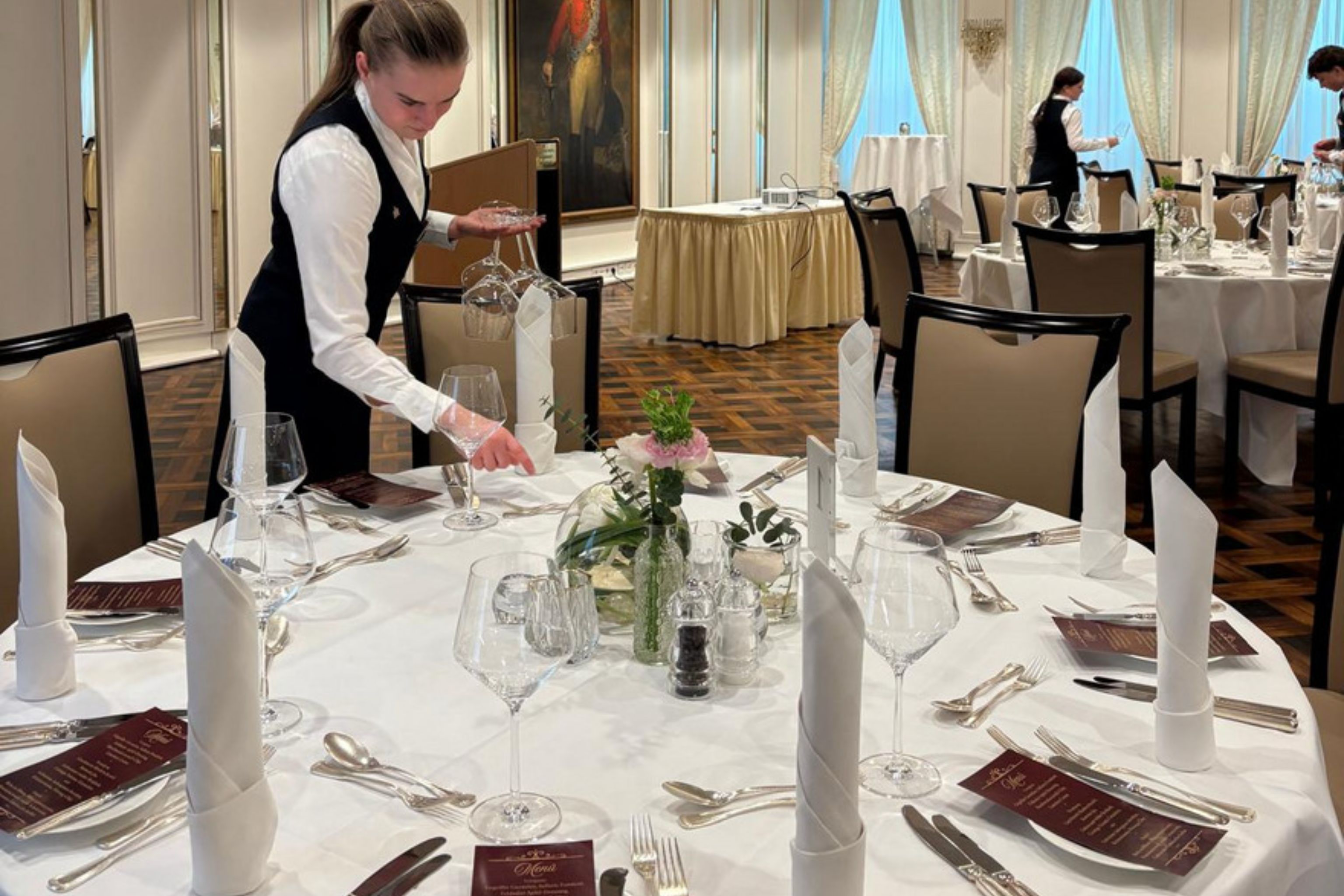 Azubi deckt den Tisch im Restaurant