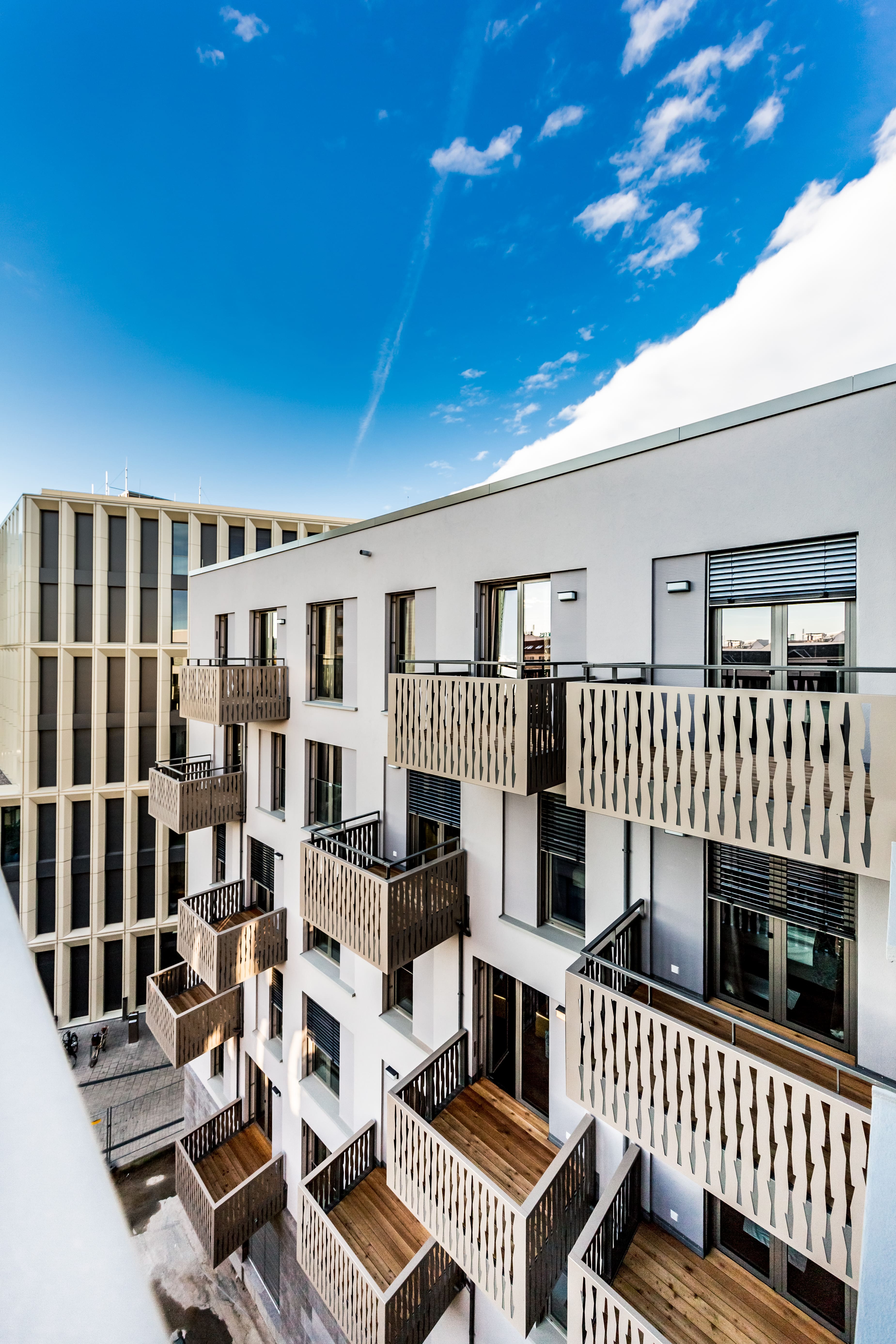 Inviting design for relaxing stays Modern hotel facade with stylish balconies under a blue sky