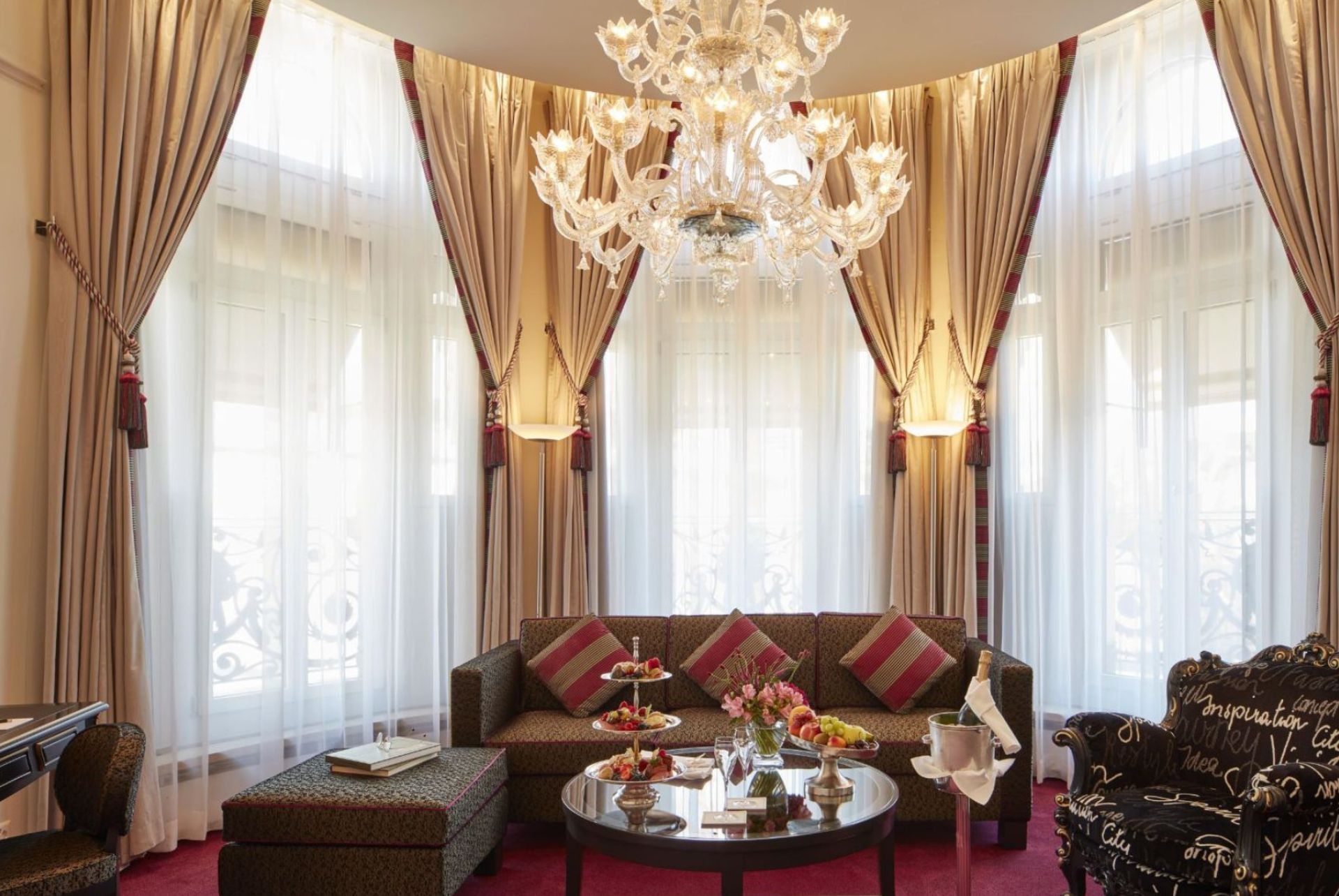 Luxurious hotel lounge area of the Luxury Collection with fine furnishings, opulent curtains and a magnificent chandelier