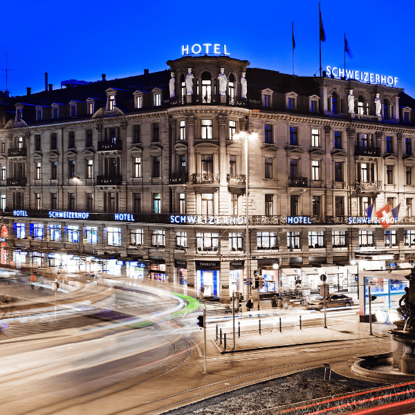 Historisches Stadthotel mit leuchtendem Schriftzug bei Nacht – zentral gelegen an einer Hauptstraße